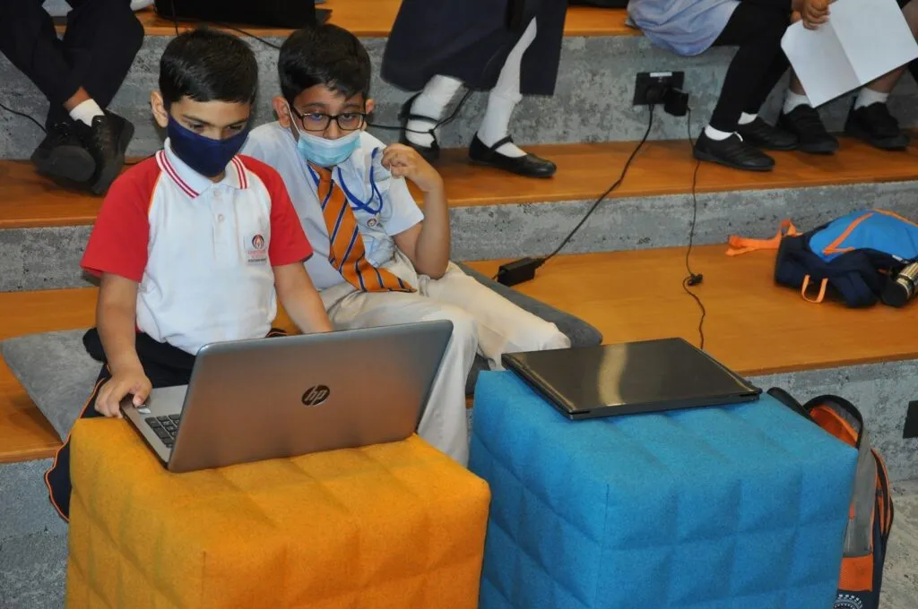 Two students build a coding project together on a laptop at Code Battle 2022 in Dubai