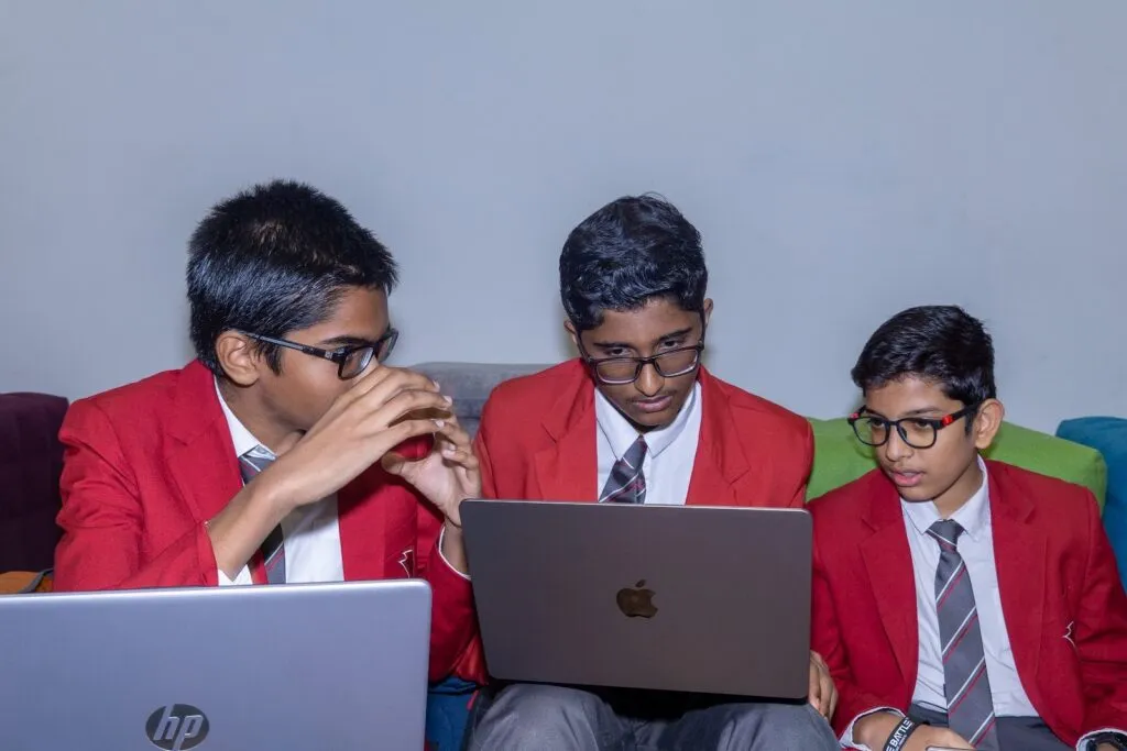 A school team in red blazers works on its project at the Code Battle 2023 national final