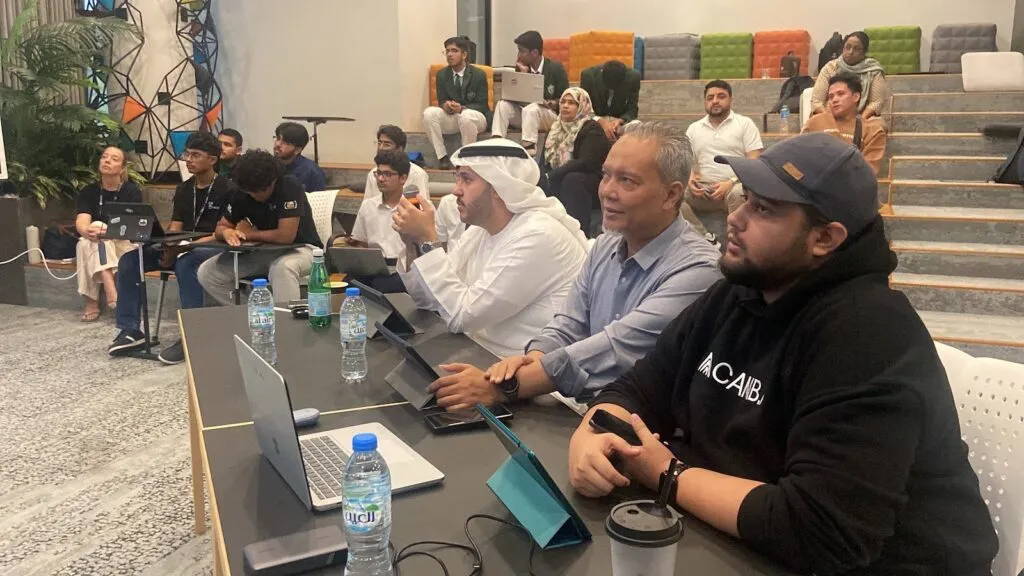Judges at Code Battle 2025 watch a student team pitch its project