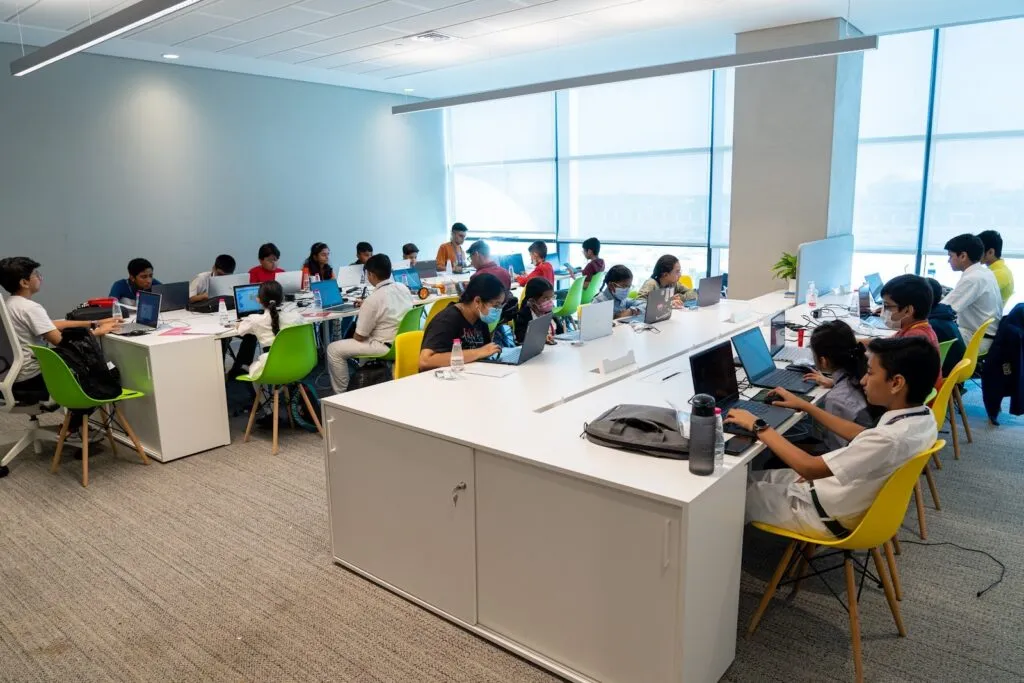 Rows of children coding on laptops in the CodeNova area at the Sharjah Entrepreneurship Festival 2022